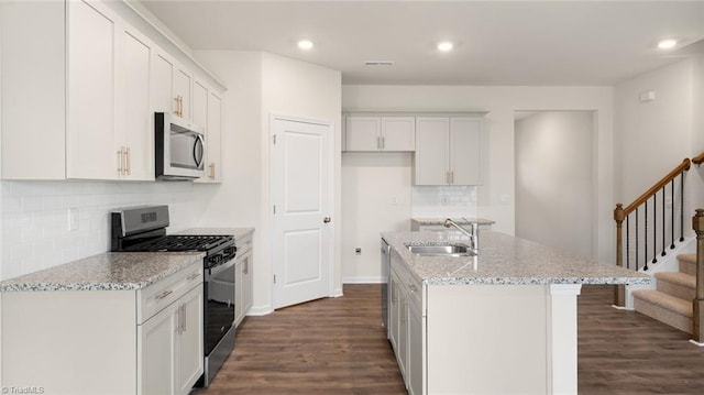 kitchen with sink, stainless steel appliances, dark hardwood / wood-style floors, an island with sink, and white cabinets