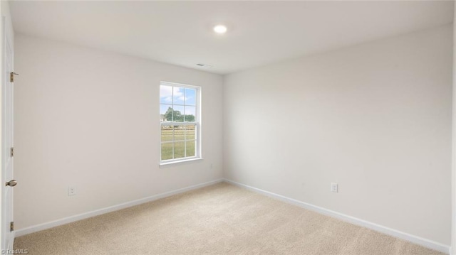 unfurnished room featuring light carpet