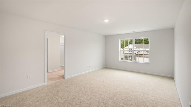 unfurnished room featuring light colored carpet