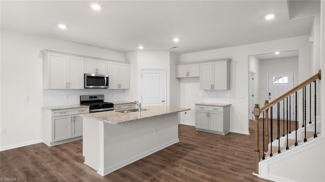 319 Willowbrooke Way, Stokesdale, NC 27357 - kitchen with appliances with stainless steel finishes, a sink, decorative backsplash, an island with sink, and white cabinetry