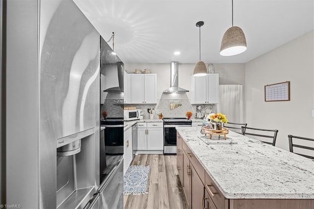 7517 NC Highway 62, Trinity, NC 27370 - kitchen featuring stainless steel appliances, wall chimney range hood, a center island, light wood-style floors, and decorative backsplash