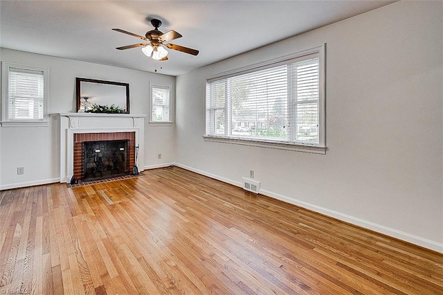 unfurnished living room with light wood-type flooring, a fireplace, and ceiling fan