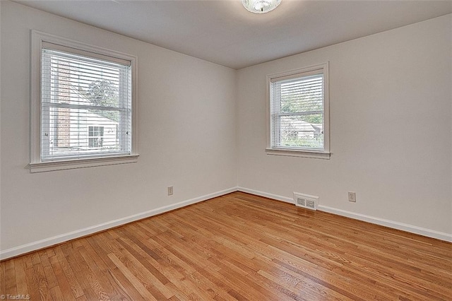 unfurnished room featuring plenty of natural light and light hardwood / wood-style flooring