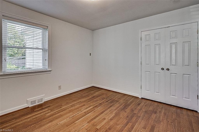 unfurnished bedroom featuring hardwood / wood-style flooring and a closet