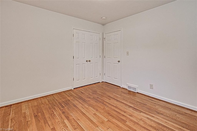 unfurnished room with wood-type flooring