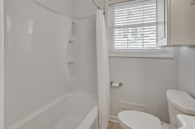 bathroom with toilet and shower / tub combo with curtain