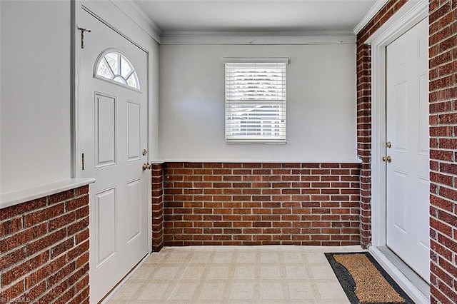 foyer entrance featuring a wealth of natural light, brick wall, and crown molding