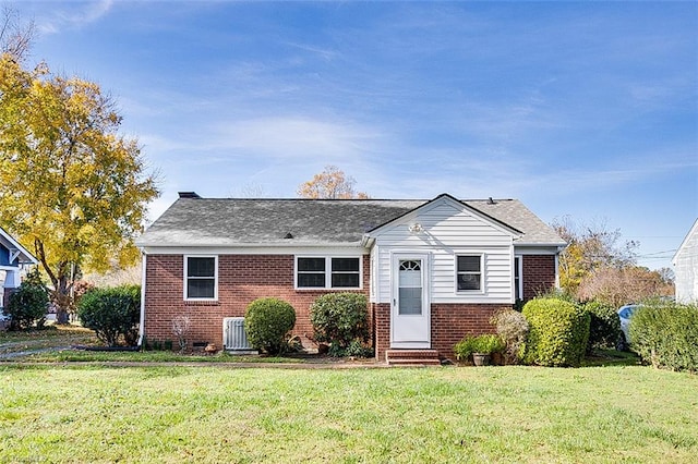 view of front of property featuring a front yard and central AC