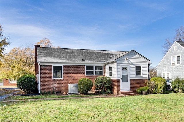 view of front of home with central AC unit and a front yard