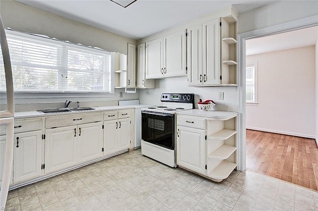 kitchen featuring white cabinetry, light wood-type flooring, a wealth of natural light, and electric range