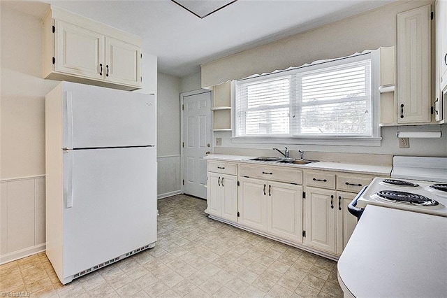 kitchen featuring white cabinets, sink, and white appliances