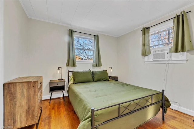 bedroom featuring multiple windows, hardwood / wood-style floors, crown molding, and cooling unit