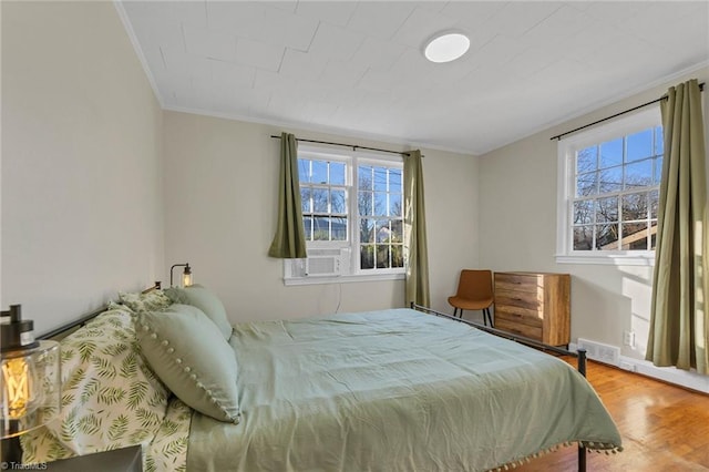 bedroom featuring hardwood / wood-style floors, ornamental molding, and cooling unit