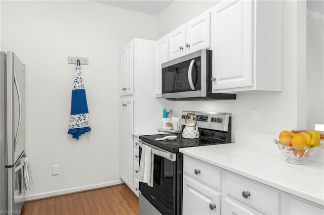 130 W Brick Walk Ct, Mocksville, NC 27028 - kitchen featuring appliances with stainless steel finishes, white cabinetry, light wood-style floors, and light stone countertops