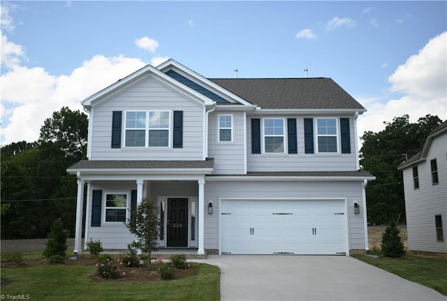 view of front of property with driveway, roof with shingles, an attached garage, and a front yard