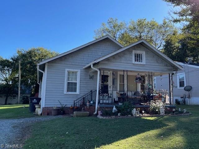 bungalow-style home with a front yard and covered porch