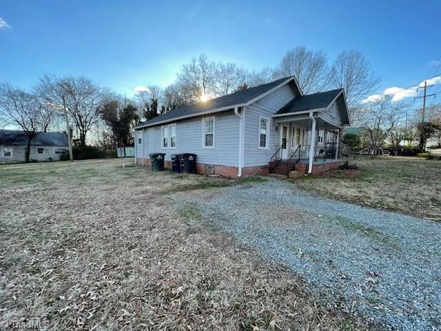 view of side of home with a porch and crawl space