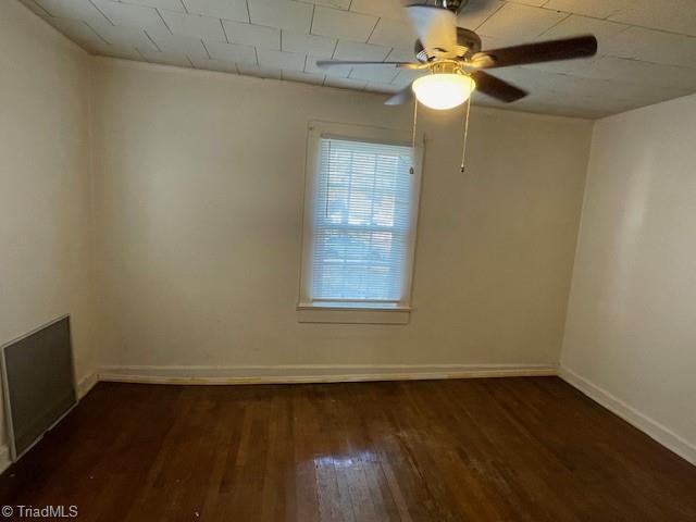 unfurnished room featuring dark hardwood / wood-style floors and ceiling fan