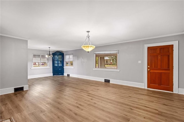 interior space featuring crown molding, hardwood / wood-style floors, and a wealth of natural light