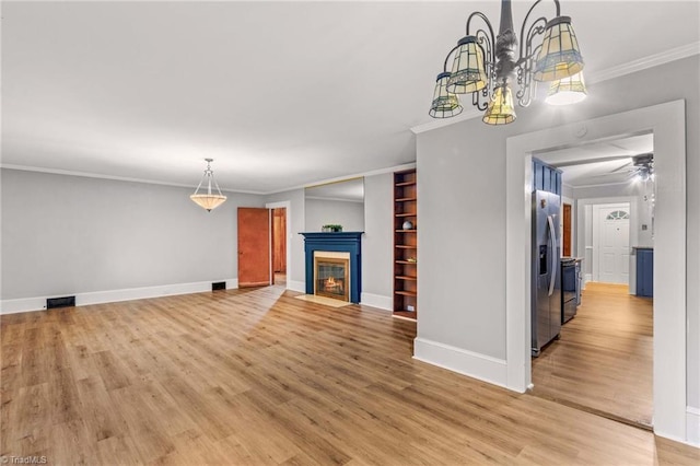 unfurnished living room with ornamental molding, light wood-type flooring, and ceiling fan