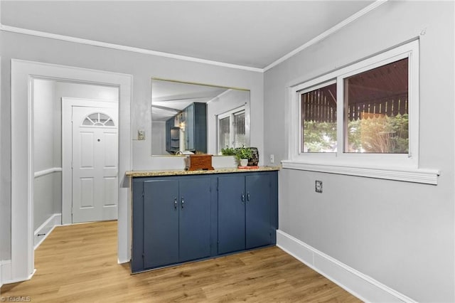 interior space with light wood-type flooring, crown molding, and blue cabinetry