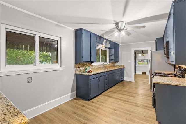 kitchen featuring ceiling fan with notable chandelier, light hardwood / wood-style floors, blue cabinets, and stainless steel appliances