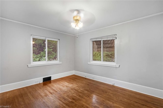 empty room featuring hardwood / wood-style flooring, crown molding, and ceiling fan