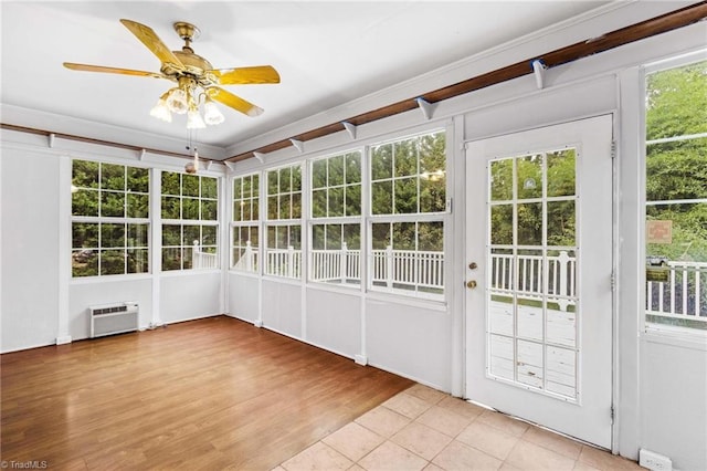 unfurnished sunroom with a wall mounted air conditioner and ceiling fan