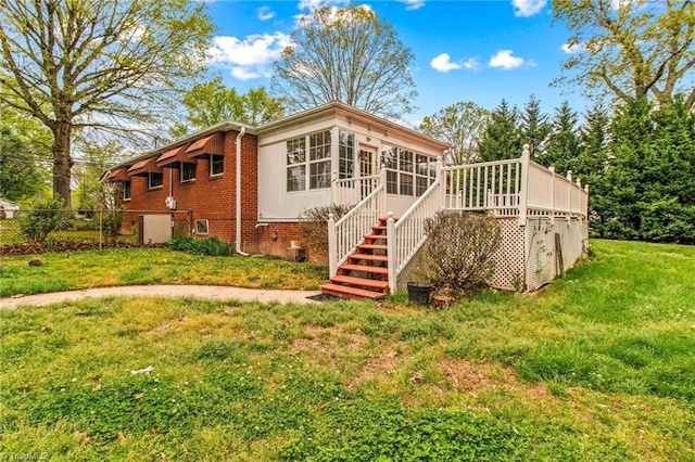 back of property with a yard and a sunroom