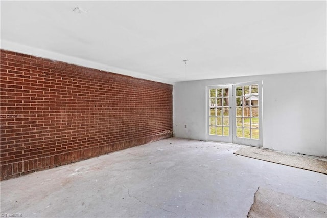 unfurnished room featuring brick wall