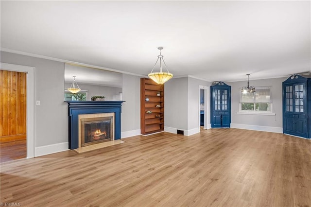 unfurnished living room with crown molding and light wood-type flooring