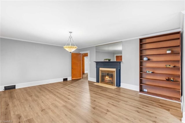 unfurnished living room featuring light wood-type flooring and crown molding