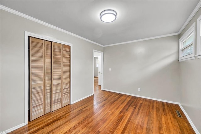 2508 Netherwood Dr, Greensboro, NC 27408 - unfurnished bedroom with wood finished floors, crown molding, and a closet