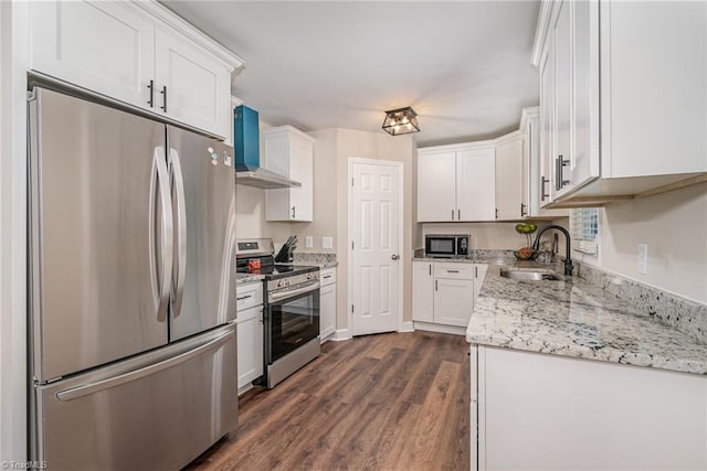 kitchen featuring wall chimney range hood, sink, stainless steel appliances, dark hardwood / wood-style floors, and white cabinets