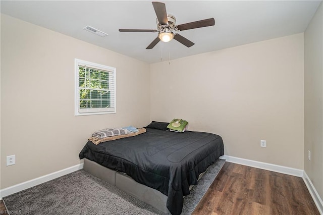 bedroom with ceiling fan and dark hardwood / wood-style flooring