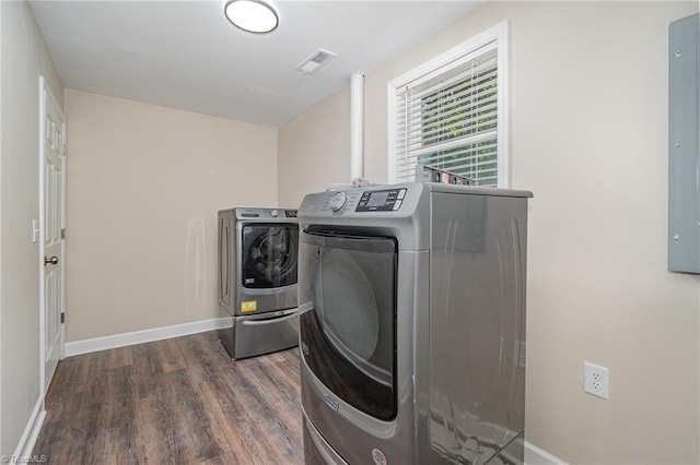 washroom with washing machine and clothes dryer and dark hardwood / wood-style flooring