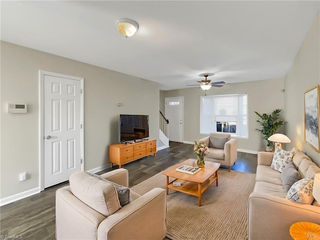 living room featuring dark wood-type flooring and ceiling fan