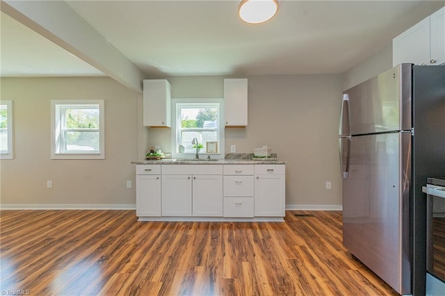 kitchen with freestanding refrigerator, wood finished floors, plenty of natural light, and a sink