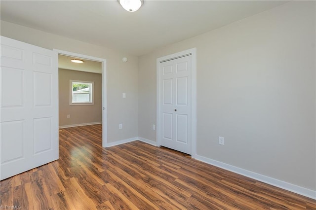 spare room featuring baseboards and wood finished floors