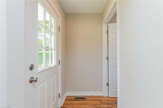 doorway to outside featuring baseboards, wood finished floors, and visible vents