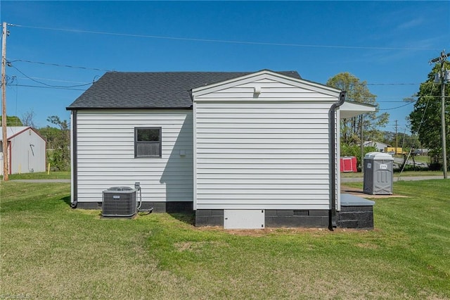view of side of home with central AC, crawl space, and a yard