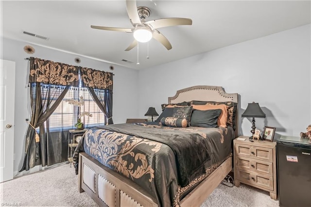 bedroom featuring visible vents, light colored carpet, and ceiling fan