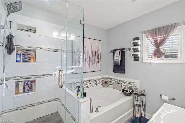 full bathroom with a shower stall, a bath, and a sink