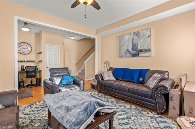 living room featuring stairs, wood finished floors, and a ceiling fan