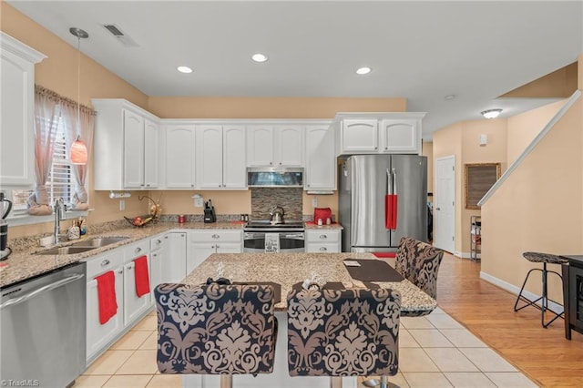 kitchen with a sink, appliances with stainless steel finishes, ventilation hood, and light tile patterned floors