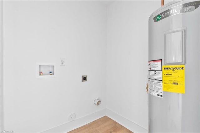 clothes washing area featuring gas dryer hookup, washer hookup, hardwood / wood-style flooring, water heater, and hookup for an electric dryer