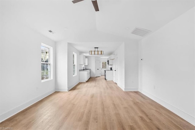 unfurnished living room featuring ceiling fan, sink, and light hardwood / wood-style flooring