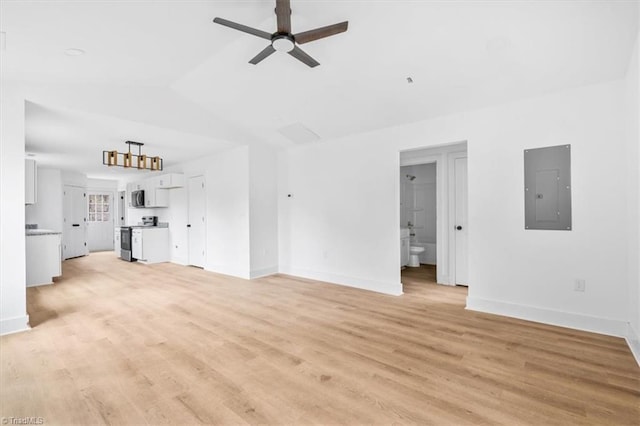 unfurnished living room with ceiling fan, light wood-type flooring, electric panel, and vaulted ceiling