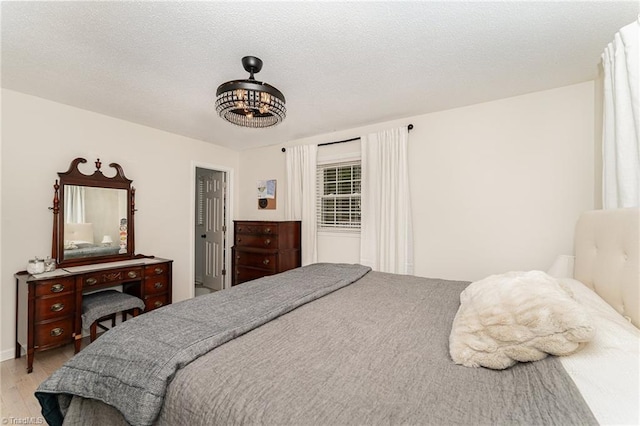 bedroom with a textured ceiling and light hardwood / wood-style flooring