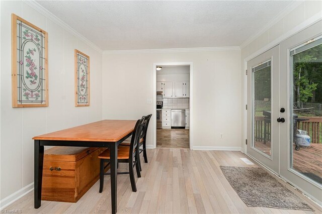 dining room with ornamental molding, light hardwood / wood-style flooring, and french doors